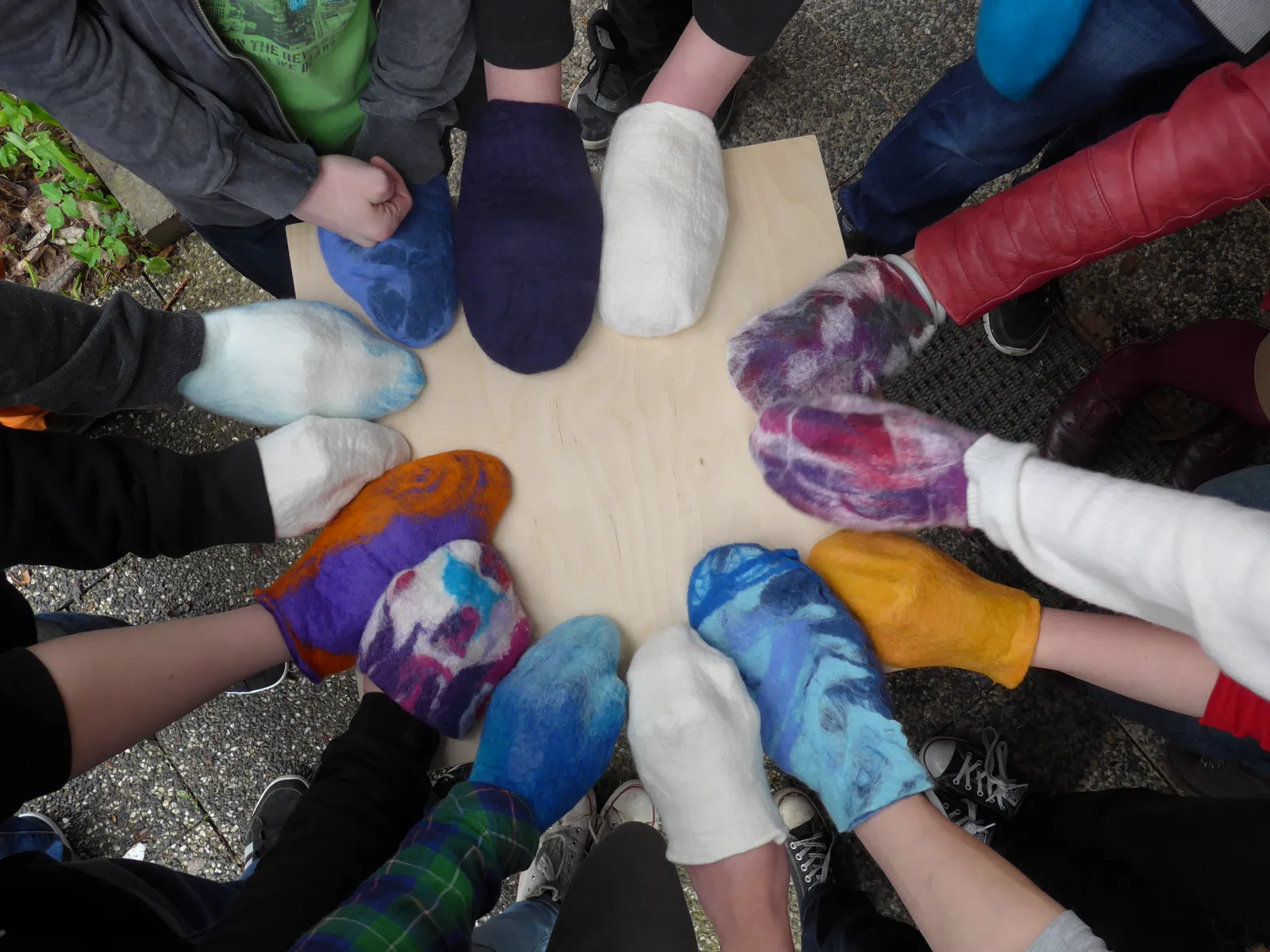 Bunte gefilzte Hausschuhe im Kreis: Ergebnis eines kunsttherapeutischen Team-Workshops